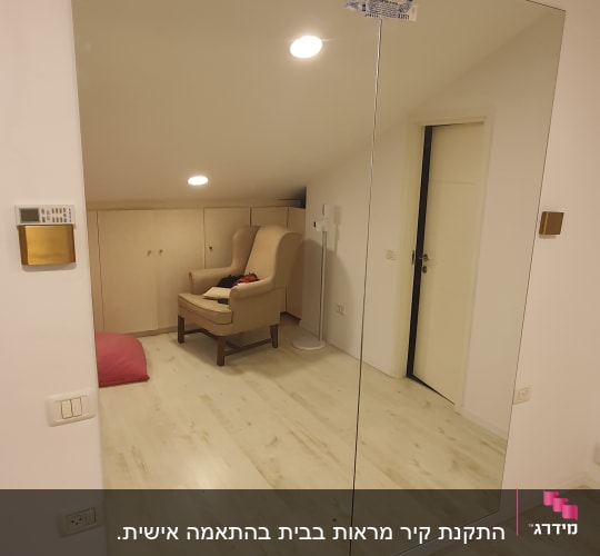 מראה גדולה על קיר עם מדבקה בפינה